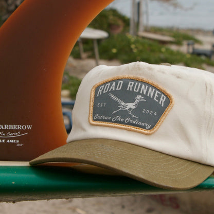 Surfboard with fins and a cap on a beach
